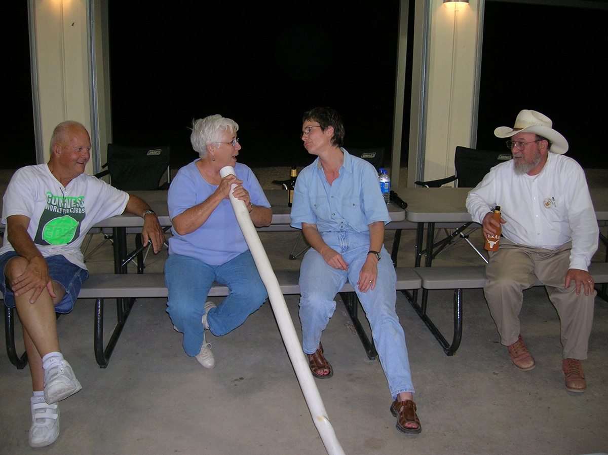 Missy Harrington uses a PVC didgeridoo while Carolyn, Jack Harrington, and Elton Prewitt look on during the 2005 Pecos Experience.