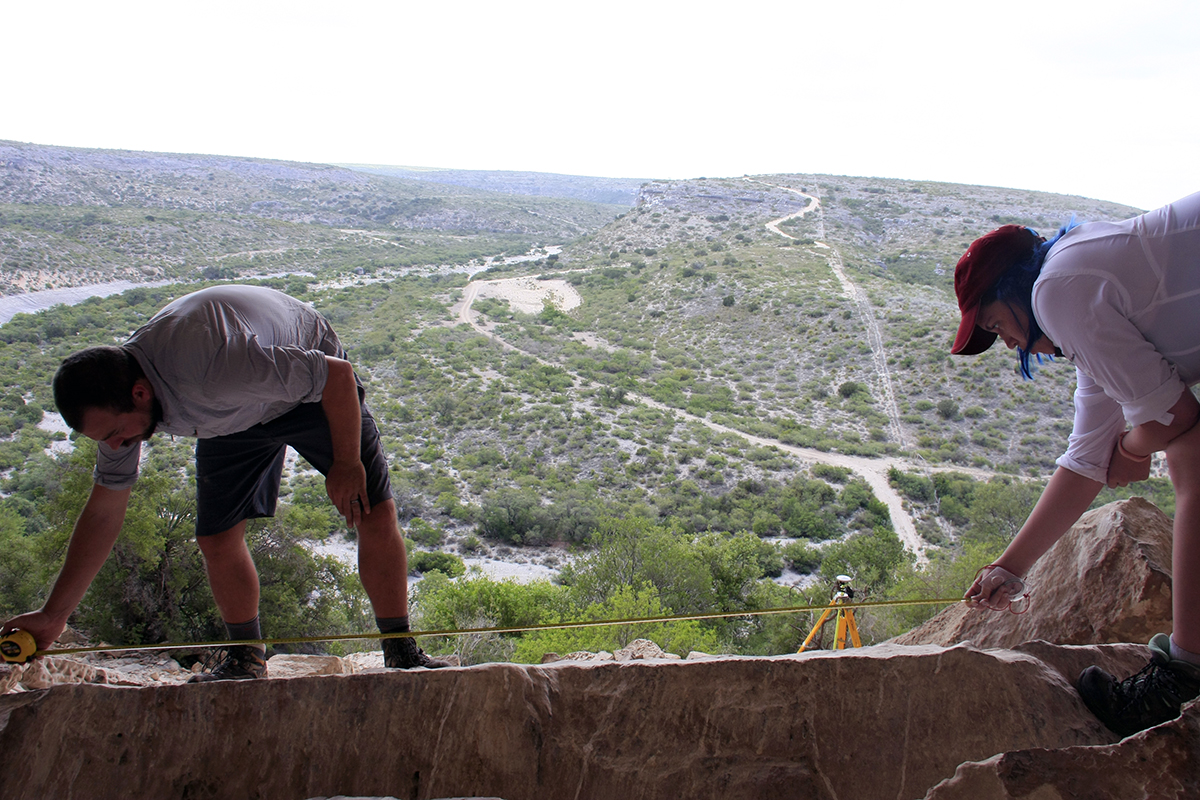 Hailey and Charles measure one of the petroglyph panels.