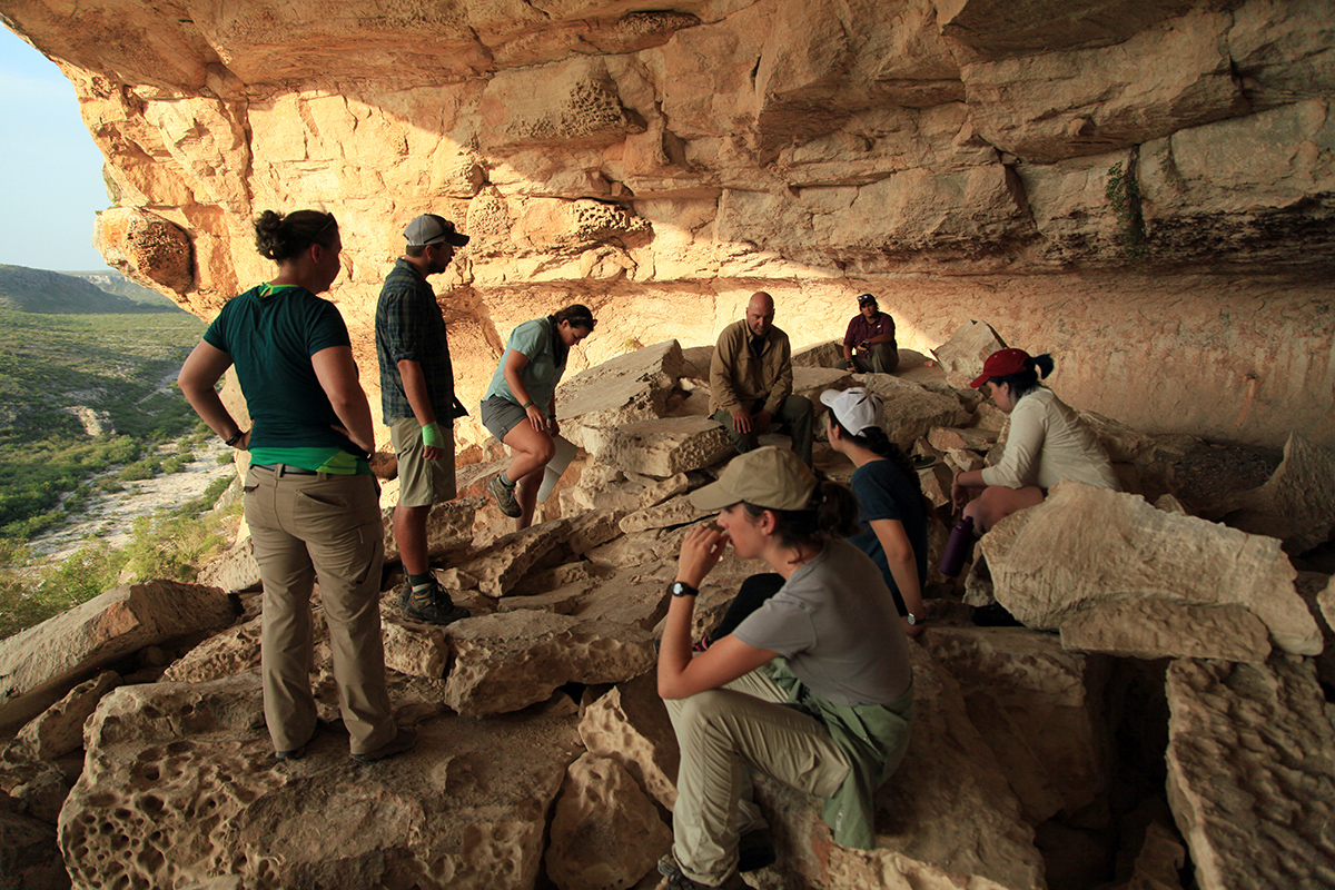 The Shumla team sitting on the boulders looking at the petroglyphs and getting a game plan together for the week.
