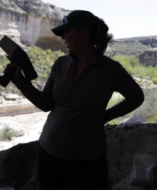 A candid photo of Dr. Karen Steelman posing as one of Charlie's Angels while looking at pXRF readings from Eagle Cave.