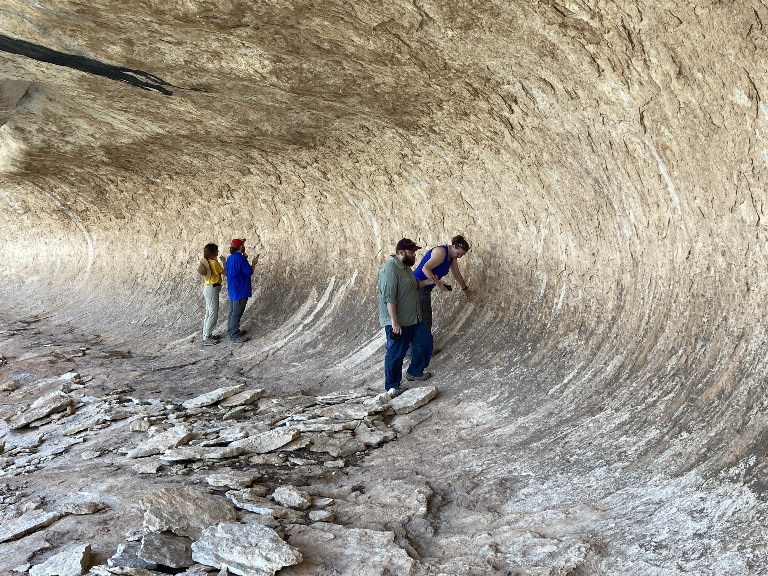 A team of volunteers inspecting a rock art panel with Texas State Master’s student, Jerod Roberts.